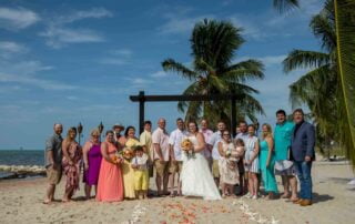 A wedding party posing for a photo on the picturesque beach