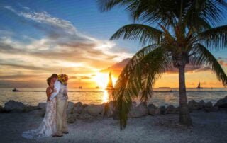 A beautiful bride and groom capturing their special moment on the beach at sunset, with the assistance of a skilled key west wedding photographer.