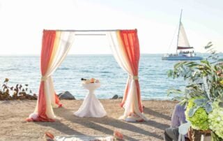 A picturesque beach wedding ceremony with a sailboat in the background, captured beautifully by a Key West wedding photographer.