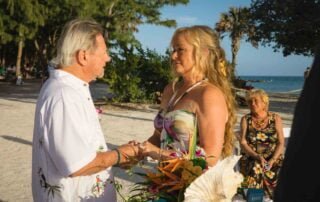 A man and woman are exchanging heartfelt vows on the scenic beach, captured beautifully by a talented key west wedding photographer.