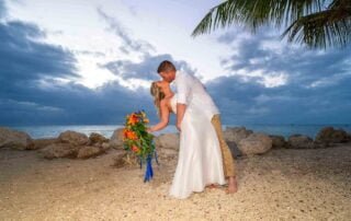 A bride and groom share a romantic kiss on the beautiful beach of Key West at sunset, captured by a talented Key West wedding photographer.
