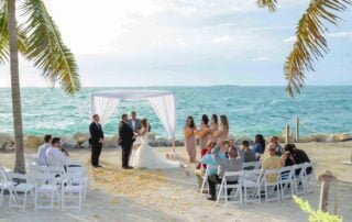 A beautiful beach wedding ceremony enhanced by palm trees, captured by a talented Key West wedding photographer.