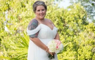 A bride in a white wedding dress holding a beautiful bouquet, captured by a talented Key West wedding photographer.