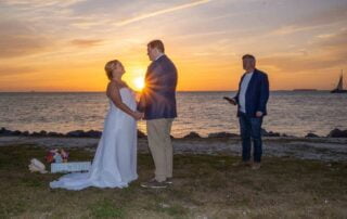 A bride and groom enjoying their romantic wedding ceremony in Key West, with the breathtaking ocean backdrop at sunset.
