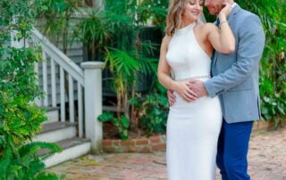 Key West wedding photographer captures a cherished moment as a bride and groom pose for a photo in front of a house.