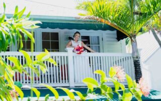 A bride standing on the balcony of a picturesque white house in Key West.
