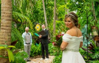 A bride and groom exchanging vows in a tropical garden, with the help of key west wedding planners to create the perfect day.