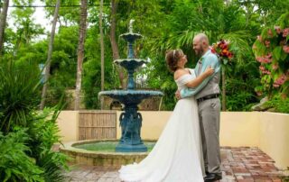 A bride and groom embracing in front of a fountain captured by a key west wedding photographer.