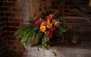 A birdcage with flowers sitting on a key west wedding officiant.