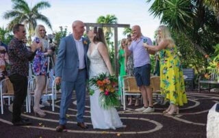 A romantic bride and groom kissing under a palm tree, surrounded by the tropical beauty of Key West.