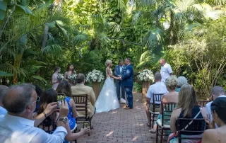 A tropical garden wedding ceremony with a bride and groom captured by a Key West wedding photographer.