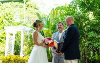 In a scenic garden setting, a couple deeply in love shares heartfelt vows during their beautiful Key West wedding ceremony.
