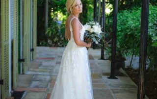 A beautiful bride in a stunning wedding dress standing in a picturesque courtyard captured by a talented Key West wedding photographer.