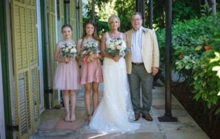 A bride and her bridesmaids pose for a photo at their beautiful Key West wedding.