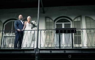 A bride and groom enjoying the romantic view from the balcony of a building during their Key West wedding ceremony.