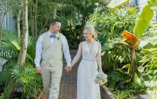 A bride and groom walking down a walkway in a tropical garden captured by a talented key west wedding photographer.