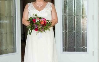 A bride in a wedding dress standing in front of a door, captured by a talented Key West wedding photographer.