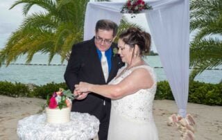 A bride and groom cutting their beach wedding cake in Key West.