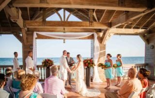 A bride and groom exchange vows under a beautiful gazebo on the beach with the assistance of a key west wedding officiant.