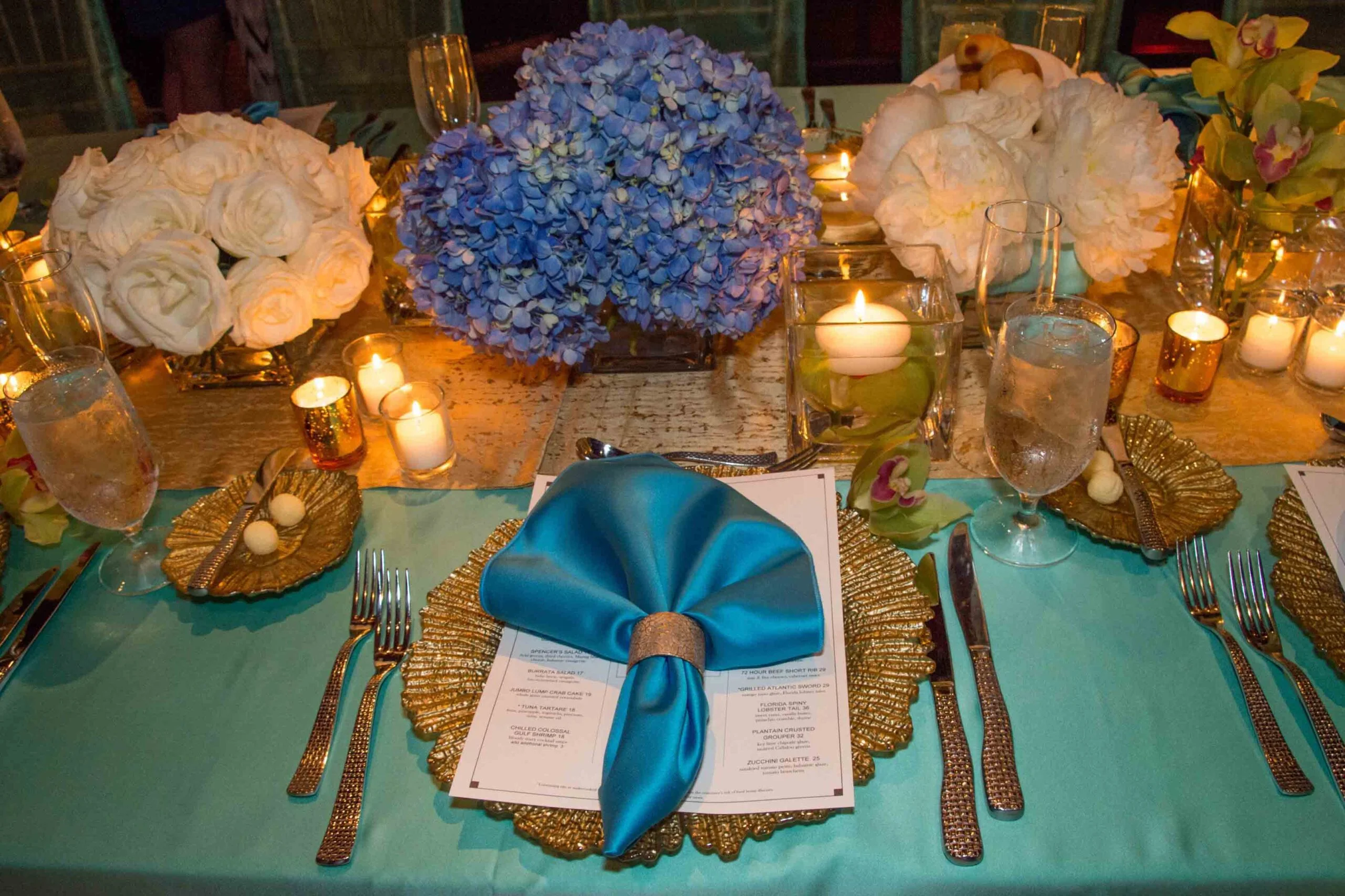 A table setting with blue napkins and flowers, perfect for Key West wedding receptions.