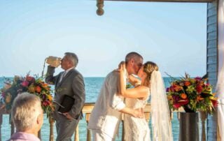 A bride and groom exchange a lingering kiss in front of the breathtaking ocean, skillfully captured by a talented key west wedding photographer.