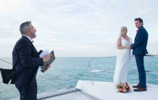 A bride and groom exchange vows on a boat, with the help of a Key West wedding officiant.