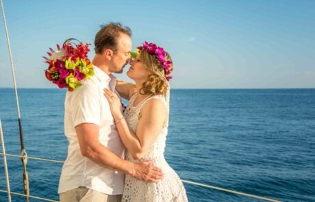 A bride and groom share a romantic kiss on the deck of a sailboat during their Key West wedding ceremony.