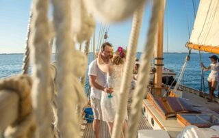 A couple sharing a romantic kiss on the deck of their sailboat during their Key West wedding ceremony.