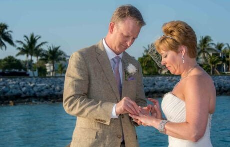 A bride and groom exchange rings on a dock during their Key West wedding.