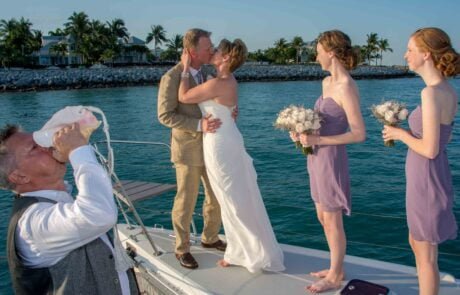 A bride and groom sharing a romantic kiss on the bow of a boat during their Key West wedding.