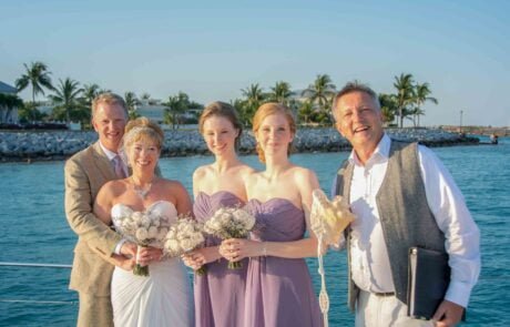 A group of bridesmaids and groom pose on a boat while capturing the magical moments of their Key West wedding.