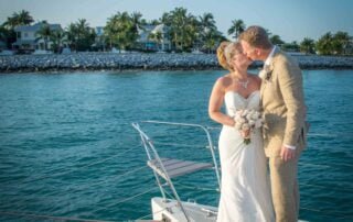 A bride and groom share a romantic kiss on the bow of a boat during their Key West wedding ceremony.