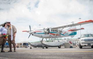 A man and woman standing next to a small plane for their Key West wedding.