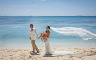 A couple enjoying their Key West wedding on the beach, with their veil blowing in the wind.