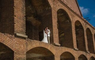A bride and groom standing in front of an old brick building during their key west wedding.