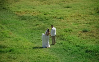 A key west wedding photographer captures a bride and groom standing in a grassy field as part of their key west wedding packages.