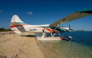 A small plane sits on the beach next to a boat in Key West, while capturing stunning photographs as part of our comprehensive wedding packages. Our team of experienced wedding planners and photographers will ensure that