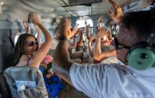 A group of people in a plane with their hands in the air, celebrating their unforgettable Key West wedding.