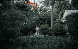 A beautiful bride and groom exchanging vows in a picturesque garden adorned with palm trees, all expertly coordinated by skillful Key West wedding planners.