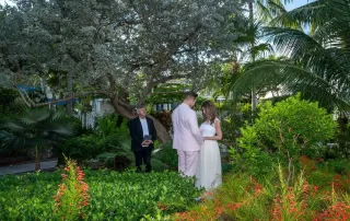A bride and groom stand in front of a picturesque tropical garden, captured beautifully by the Key West wedding photographer.
