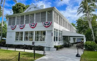A white house with American flags and palm trees