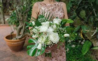 A woman in a dress holding a bouquet of white flowers captured by a Key West wedding photographer.