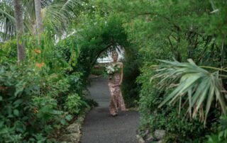 A bride walking down a path in a tropical garden during her Key West wedding ceremony.