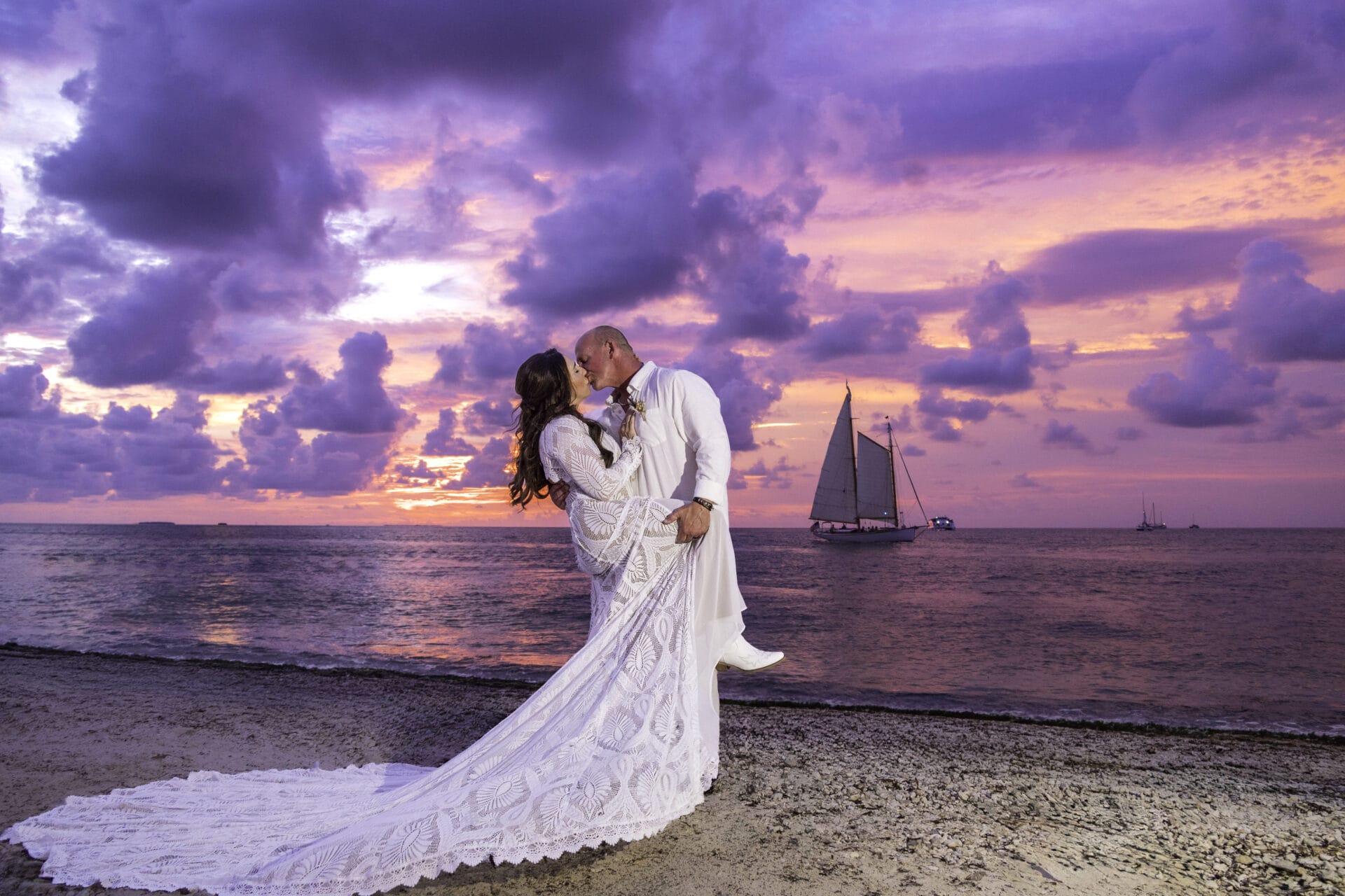 Romantic Sunset Key wedding portrait of newlyweds kissing on the beach beneath a vibrant pink-and-purple Key West sunset, photographed by Rasa Tubyte Photography. Romantic Sunset Key wedding portrait of newlyweds kissing on the beach beneath a vibrant pink-and-purple Key West sunset, photographed by Rasa Tubyte Photography.